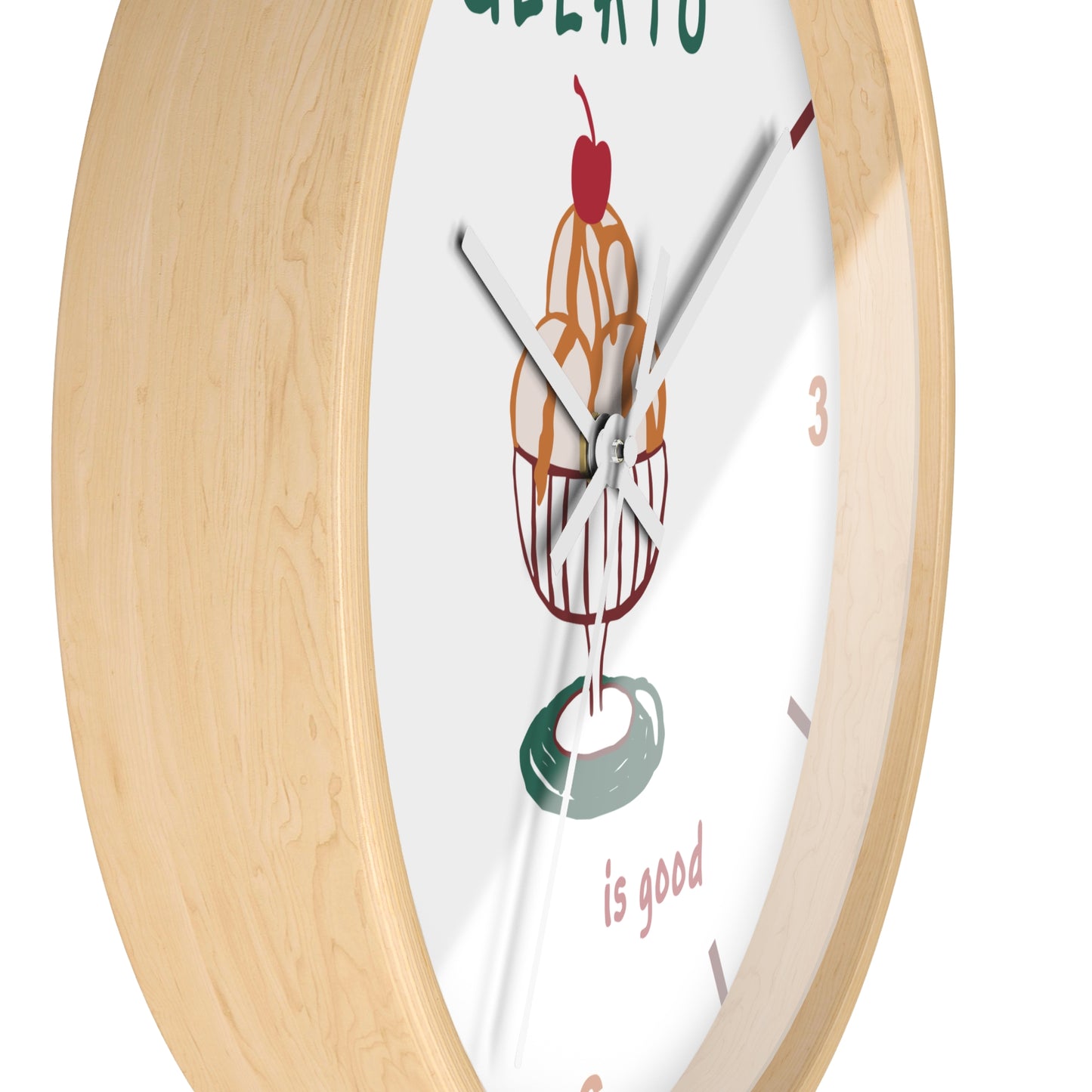 A close-up of a round wall clock with a light natural wood frame and a white face featuring a colorful ice cream cone illustration and the words 'GREAT LATO is good'.