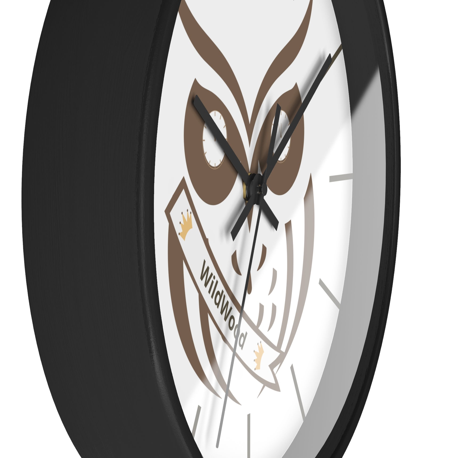 A close-up of a round wall clock with a black frame and a white face featuring a brown owl graphic and the words 'Wildwood' on a banner.