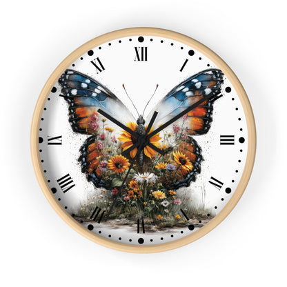 A round wall clock with a light wood frame and a white face featuring a large colorful butterfly over wildflowers, with black Roman numerals and hands on a white background.