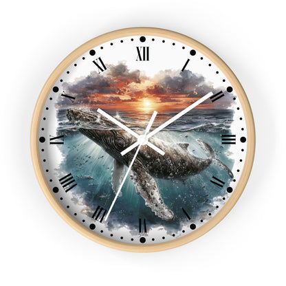 A round wall clock with a light wood frame and a printed ocean scene featuring a whale beneath a sunset sky. The clock face has black Roman numerals, black hour markers with dot details, white hands, and a white outer background.