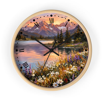 Round wall clock with a light wood frame and a scenic landscape print featuring mountains, a lake, trees, and wildflowers. The clock face uses black Roman numerals and black hands against a clean white background.