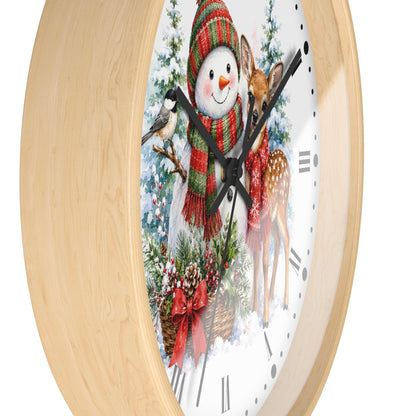 Round wall clock with a light natural wood frame and a festive winter illustration on the face, featuring a snowman, deer, bird, and evergreen branches.