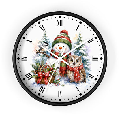 A round wall clock with a black frame and a white face featuring a festive Christmas illustration of a snowman and an owl, with black Roman numerals and clock hands.