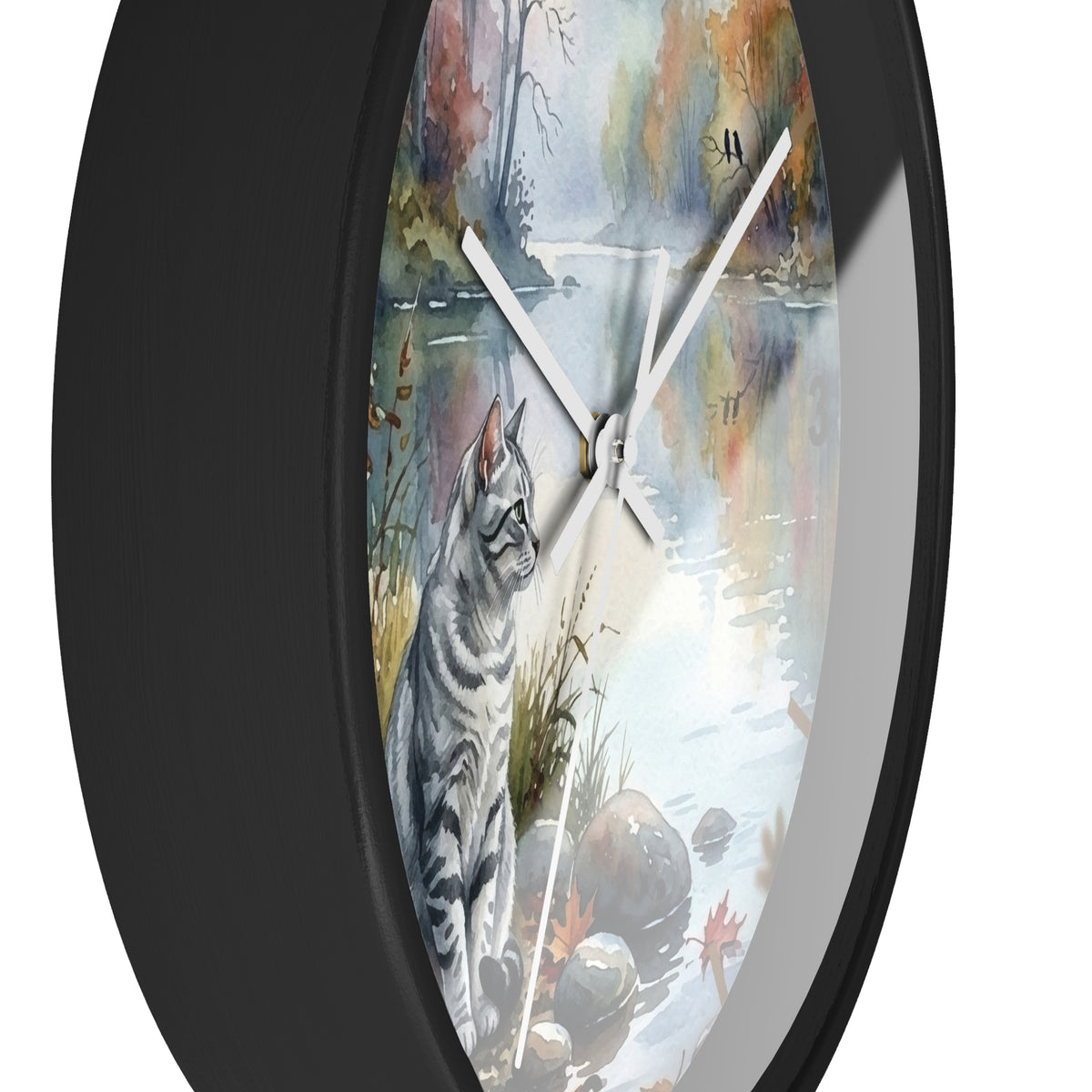 Round wall clock with a black frame and a printed cat-and-lake scene on the face, shown against a plain white background.