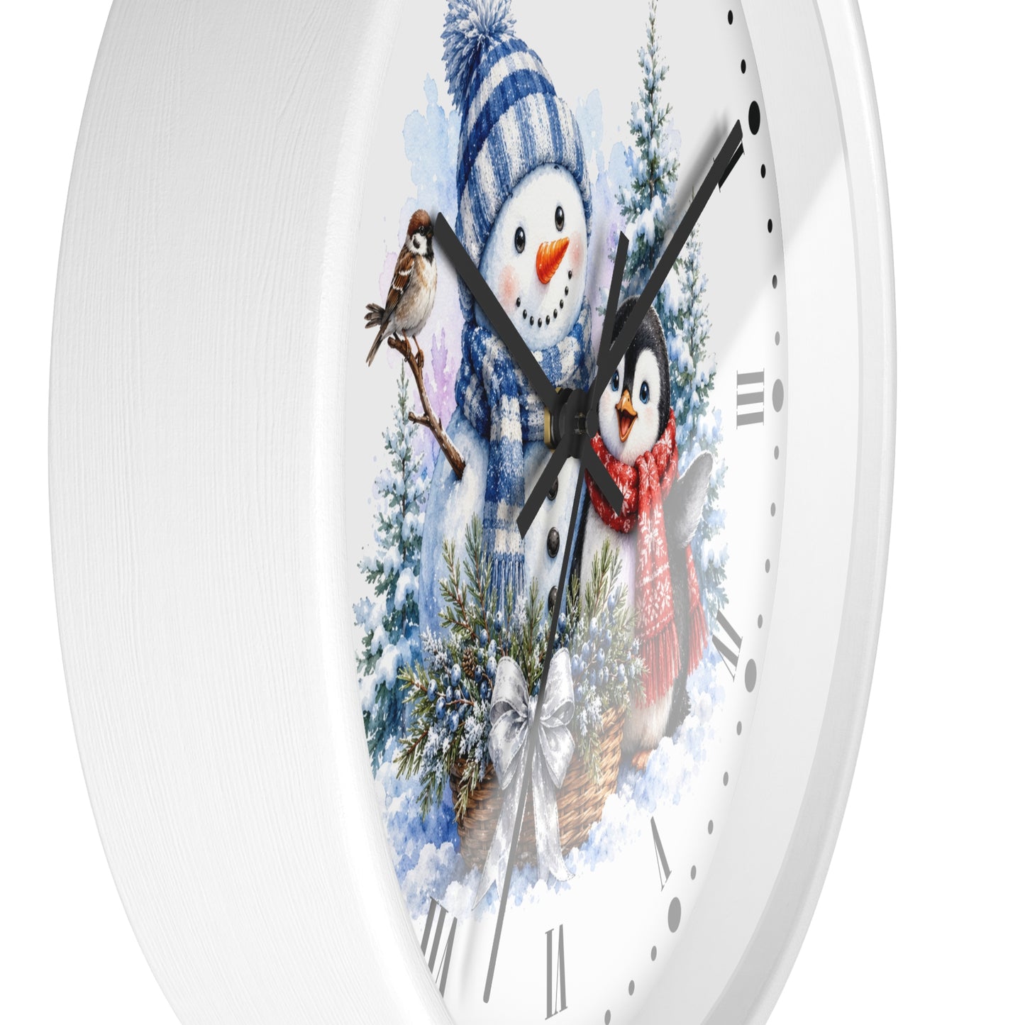 A white round wall clock with a winter-themed illustration on the face, featuring a snowman in a blue striped hat, a penguin in a red scarf, evergreen trees, and bird details. The clock is shown close-up against a white background.