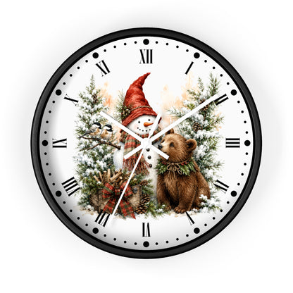 A round wall clock with a black frame and a white face featuring a winter holiday illustration of a snowman in a red hat, a bear, evergreen trees, and Roman numerals.