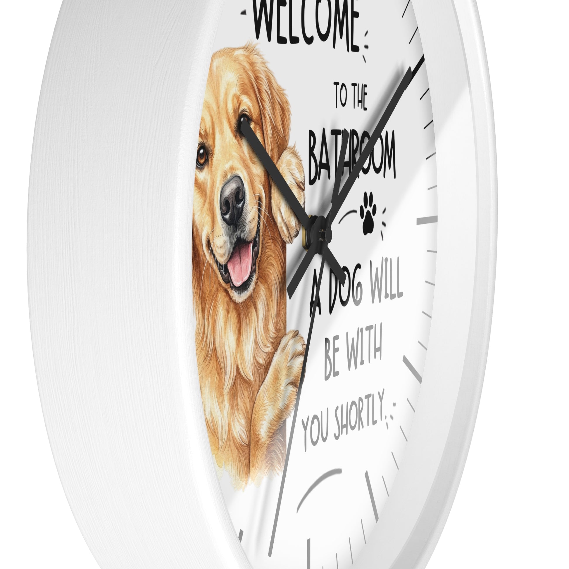 A round white wall clock with a printed face featuring a golden retriever illustration and the text 'WELCOME TO THE BATHROOM A DOG WILL BE WITH YOU SHORTLY' on a clean white background.