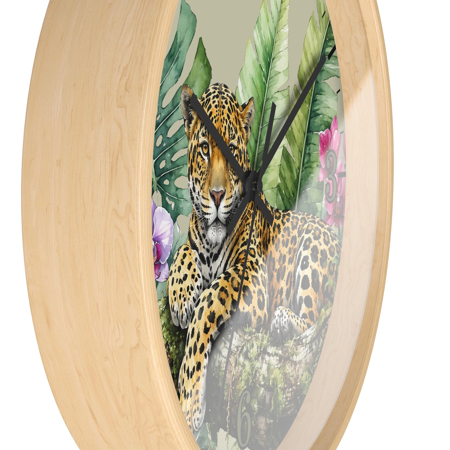 Round wall clock with a light natural wood frame and a printed tropical jungle scene featuring a leopard, large green leaves, and pink flowers on the face.