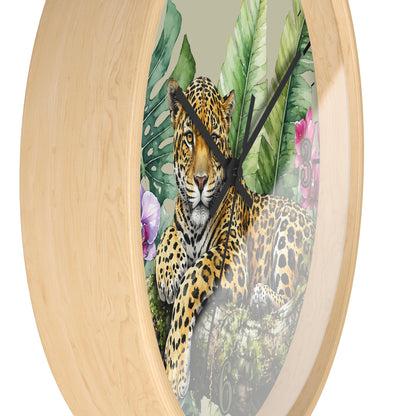 Round wall clock with a light natural wood frame and a printed tropical jungle scene featuring a leopard, large green leaves, and pink flowers on the face.
