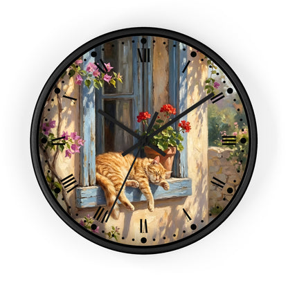 A round wall clock with a black frame and a printed illustration of an orange tabby cat resting on a blue window sill, surrounded by flowers and outdoor scenery. The clock face features black Roman numerals and black hands.