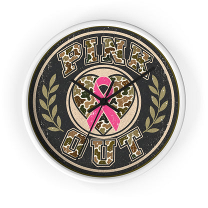A round wall clock with a distressed design featuring the words 'PINK OUT' in a camouflage pattern, a pink awareness ribbon in the center, and olive branch motifs on either side. The clock has a white outer rim and black hands, shown against a plain white background.