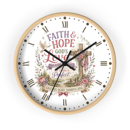 A round wall clock with a light wood frame and a white face featuring a religious design. The design includes the words 'FAITH & HOPE GOD'S LOVE', a wooden cross, roses, a dove, and Roman numerals for the hours.