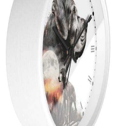 A round wall clock with a white frame and a printed dog-themed face. The artwork shows a large gray dog in profile, a smaller dog silhouette, a full moon, and a warm sunset landscape.