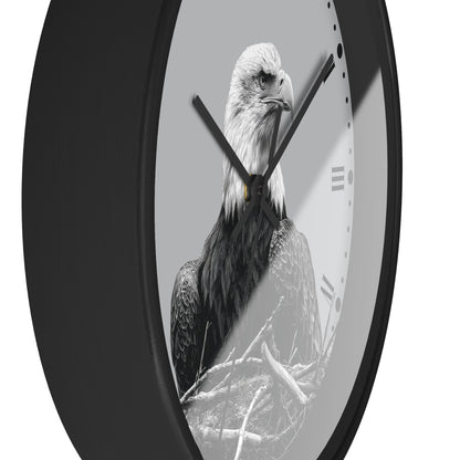 A round wall clock with a black frame and a monochrome photograph of a bald eagle on the face, with black hands and Roman numeral hour markers on a light gray background.