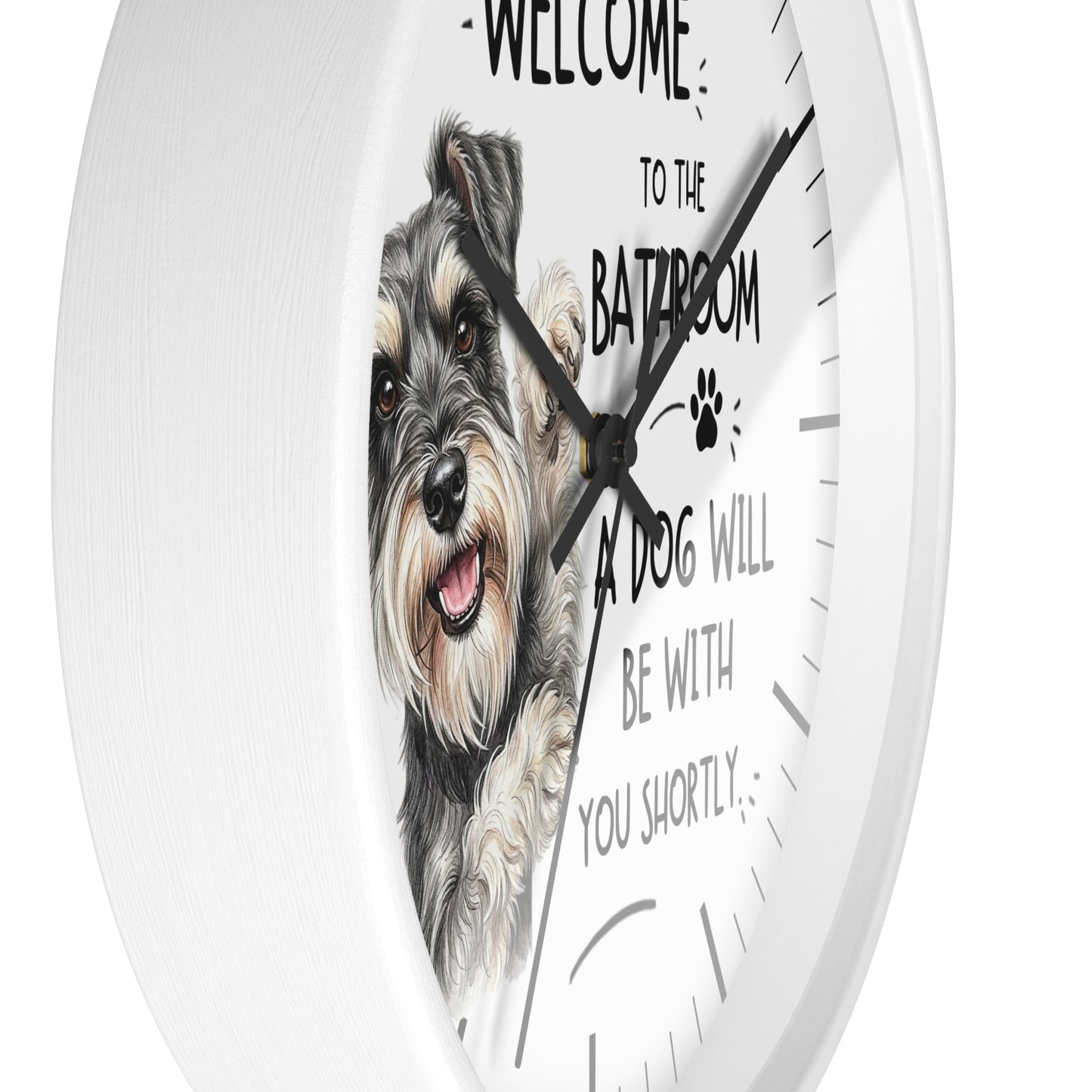 A round white wall clock with a printed illustration of a gray and white dog on the face and humorous text that reads 'WELCOME TO THE BATHROOM A DOG WILL BE WITH YOU SHORTLY'.