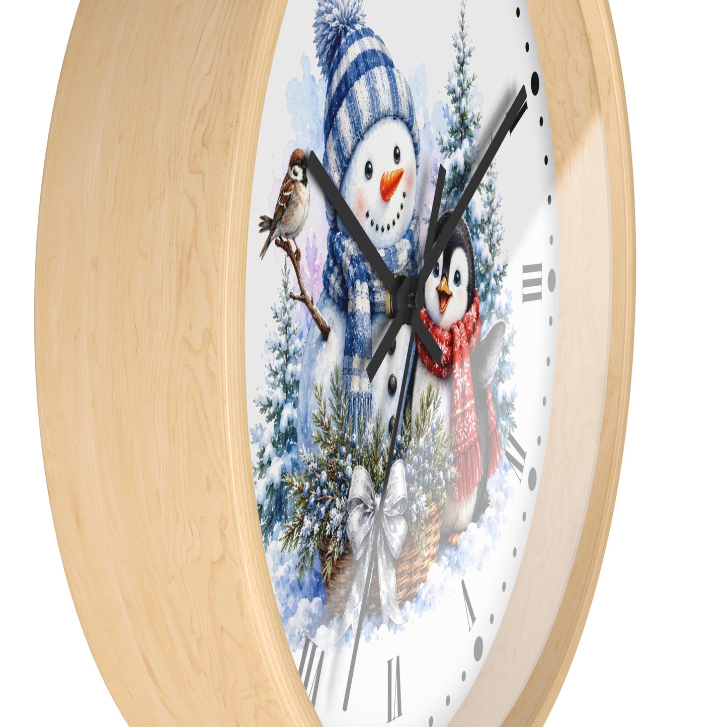 Round wall clock with a light natural wood frame and a white face featuring a winter holiday illustration of a snowman, a penguin, evergreen trees, and decorative clock hands.