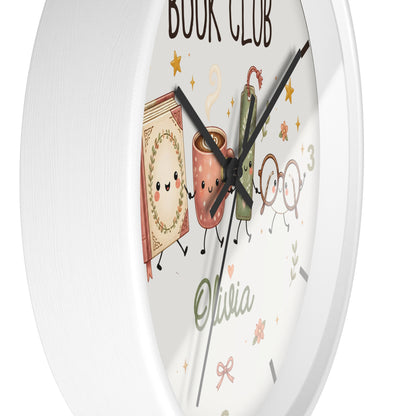 A round white wall clock with a whimsical book-themed face. The clock features cute illustrations of a book, a coffee mug, a green book, and glasses with the text 'BOOK CLUB' and the name 'Olivia' written in green script.