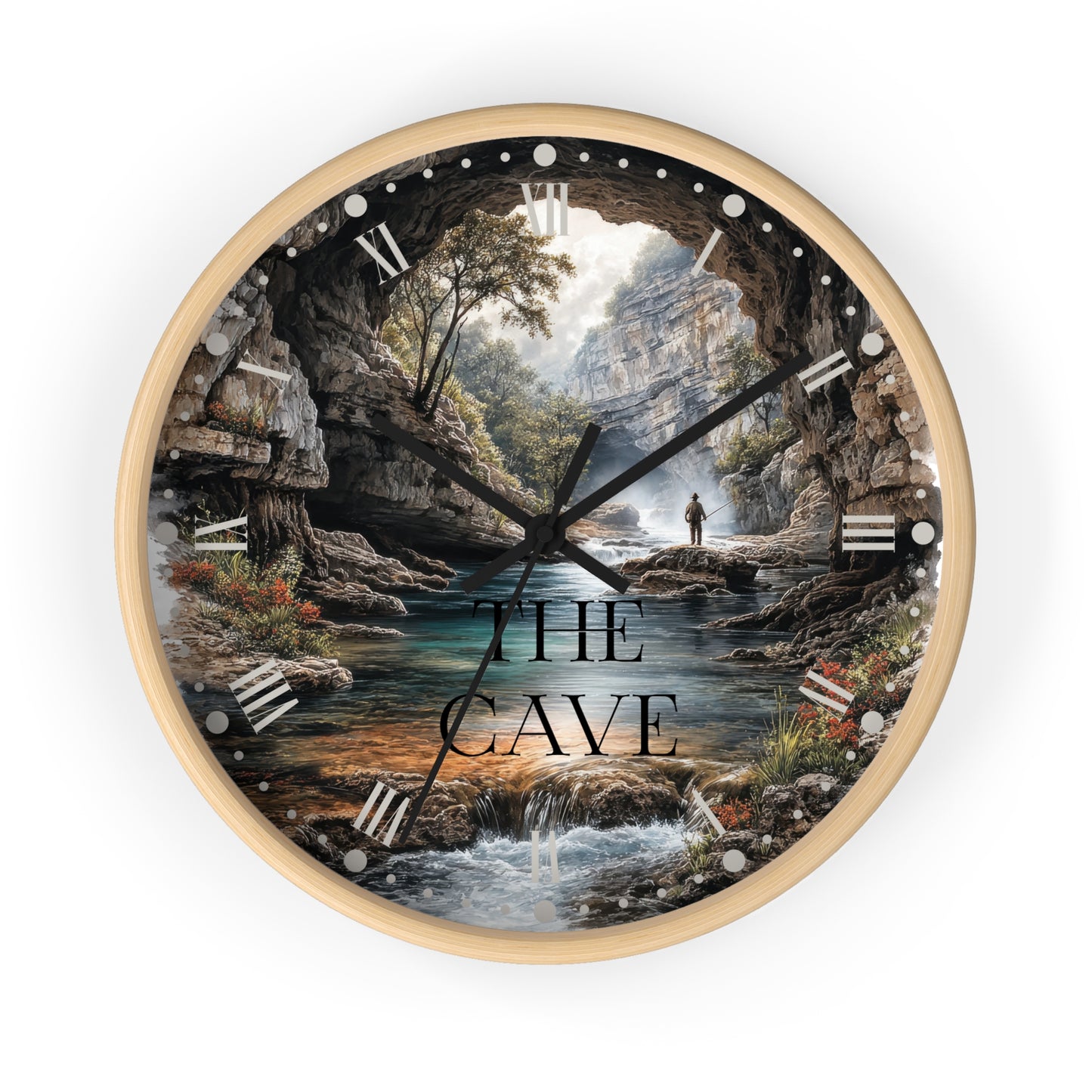 A round wall clock with a light wood frame and a scenic illustration of a cave interior, waterfall, river, and cliffs. The clock face has black hands, silver Roman numeral hour markers, and the words “THE CAVE” printed across the lower center.