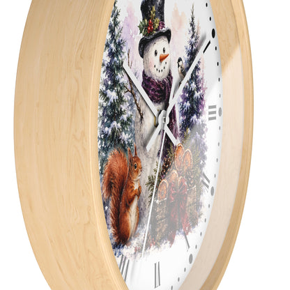 Round wall clock with a light natural wood frame and a winter scene printed on the face, featuring a snowman, squirrel, evergreen trees, and a snowy forest.