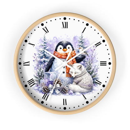 A round wall clock with a light wood frame and a white face featuring a winter illustration of a penguin and a fox among snowy trees, with black Roman numerals and black hour markers.