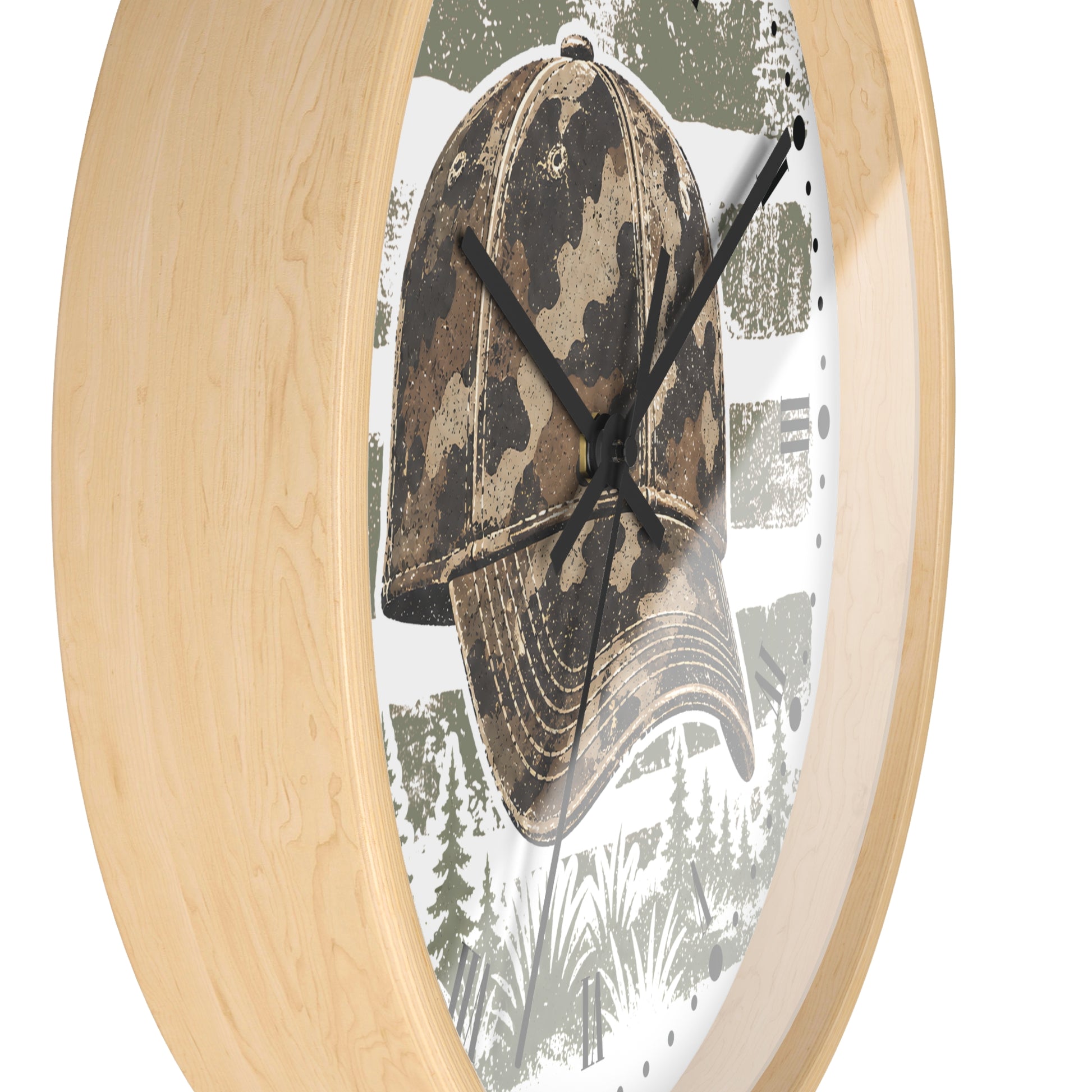 Oval wall clock with a light natural wood frame and a printed face featuring a camouflage baseball cap over a forest scene.