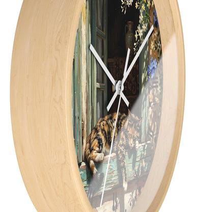 Round wall clock with a light natural wood frame and a printed scene of a cat on a window at the center, shown against a plain white background.