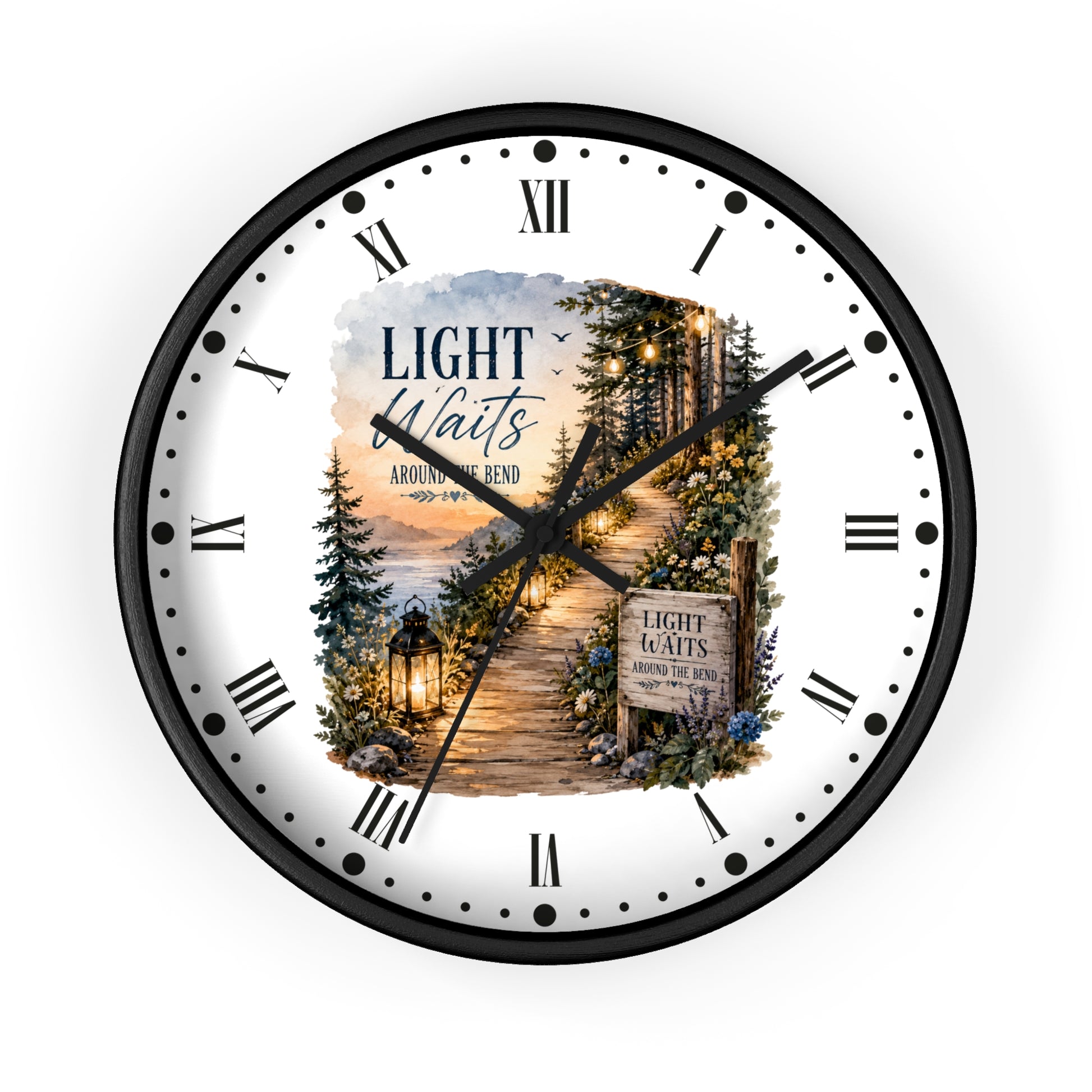 A round wall clock with a black frame and a white face featuring a scenic forest path illustration and the text 'LIGHT Waits AROUND THE Bend' .' Roman numerals mark the hours, with black hands and a small central decorative inset.