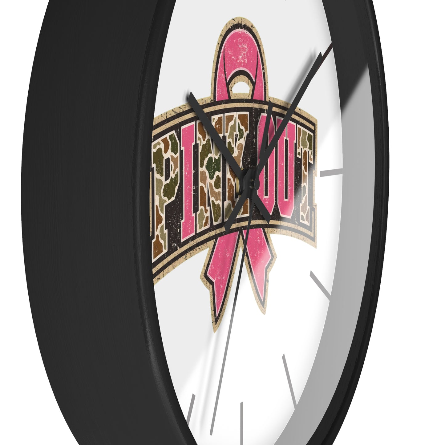 Close-up of a round wall clock with a black frame and white face, featuring a pink ribbon and leopard-print 'PINKOUT' graphic at the center.