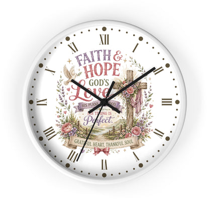 A round white wall clock with black Roman numerals and hands, featuring a central religious illustration with a cross, flowers, a dove, and the words 'Faith & Hope God's Love' and 'This plan is good, everything is perfect.'.