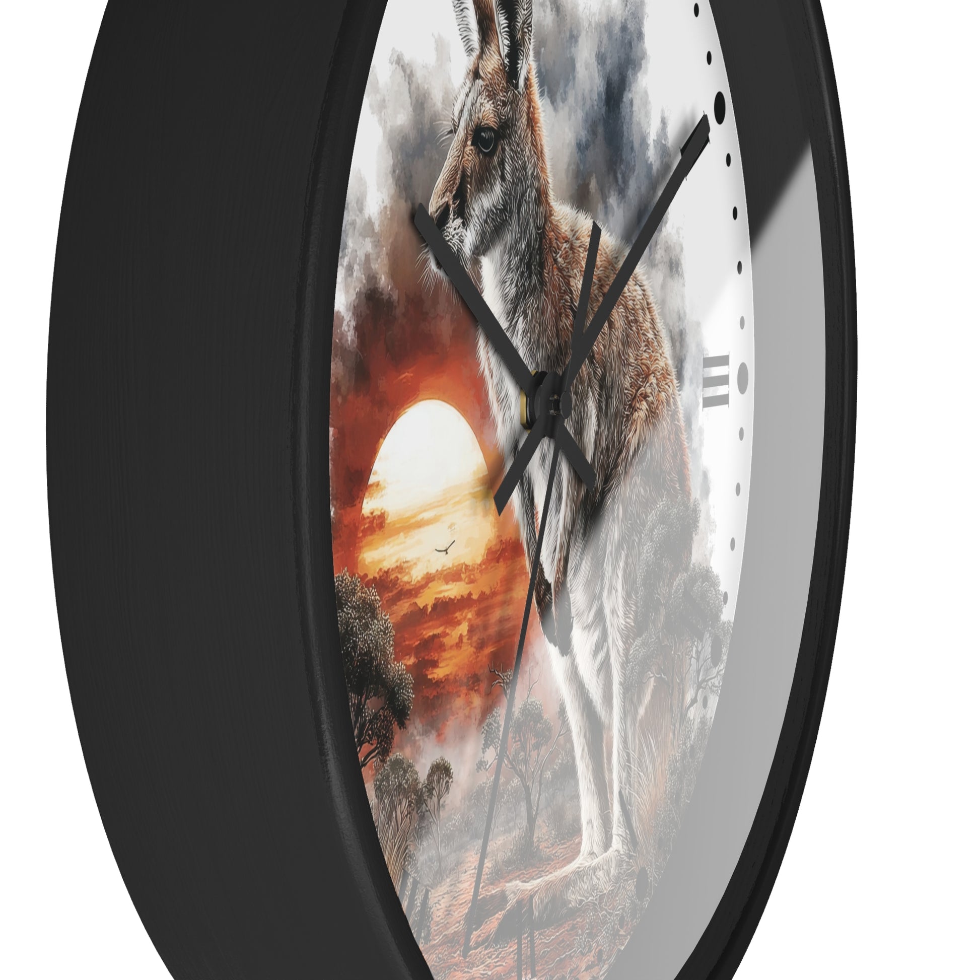 A round wall clock with a black frame and a printed artwork of a kangaroo standing in a dramatic sunset landscape. The clock face is partially visible behind the black bezel, with black hands and minimal hour markers.