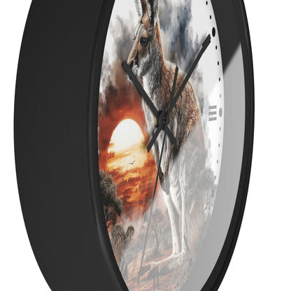 A round wall clock with a black frame and a printed artwork of a kangaroo standing in a dramatic sunset landscape. The clock face is partially visible behind the black bezel, with black hands and minimal hour markers.