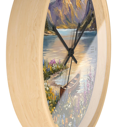 Round wall clock with a light natural wood frame and a scenic landscape print featuring a lake, mountains, flowers, and a canoe, shown against a plain white background.
