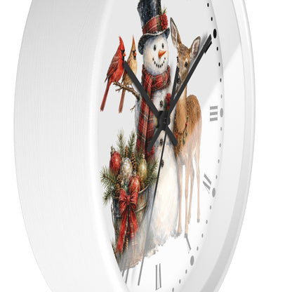 A white round wall clock with a festive Christmas illustration on the face, featuring a snowman in a black top hat and red plaid scarf, two red cardinals, a deer, evergreen branches, ornaments, and black Roman numerals.