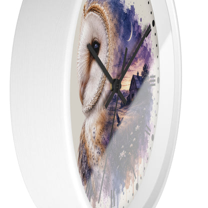 A round wall clock with a white frame, black hands, and a printed owl artwork on the face. The design shows a large white and brown owl over a purple and blue watercolor landscape with a house and moon.