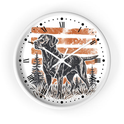 A round wall clock with a white frame and face, featuring a black dog illustration over a distressed orange and white striped background with black tree silhouettes. The clock uses black Roman numerals and black dot hour markers with white hands.