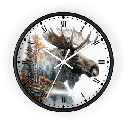 A round wall clock with a black frame and a white face featuring a moose head over a forest and water scene, with black Roman numerals and white hands.