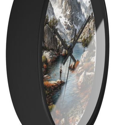 Oval wall clock with a black frame and a scenic landscape print of a mountain river, featuring black clock hands on a white background.