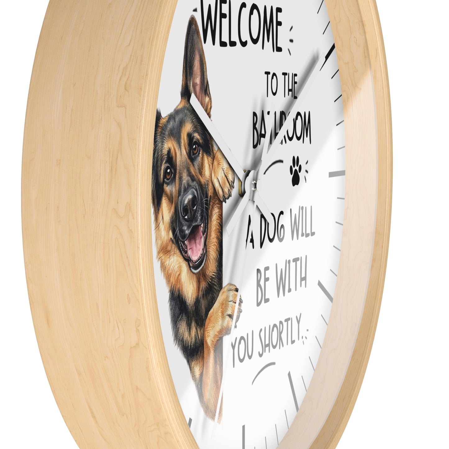 A round wall clock with a light natural wood frame and a white face featuring a German Shepherd illustration and the text 'WELCOME TO THE BATHROOM A DOG WILL BE WITH YOU SHORTLY'