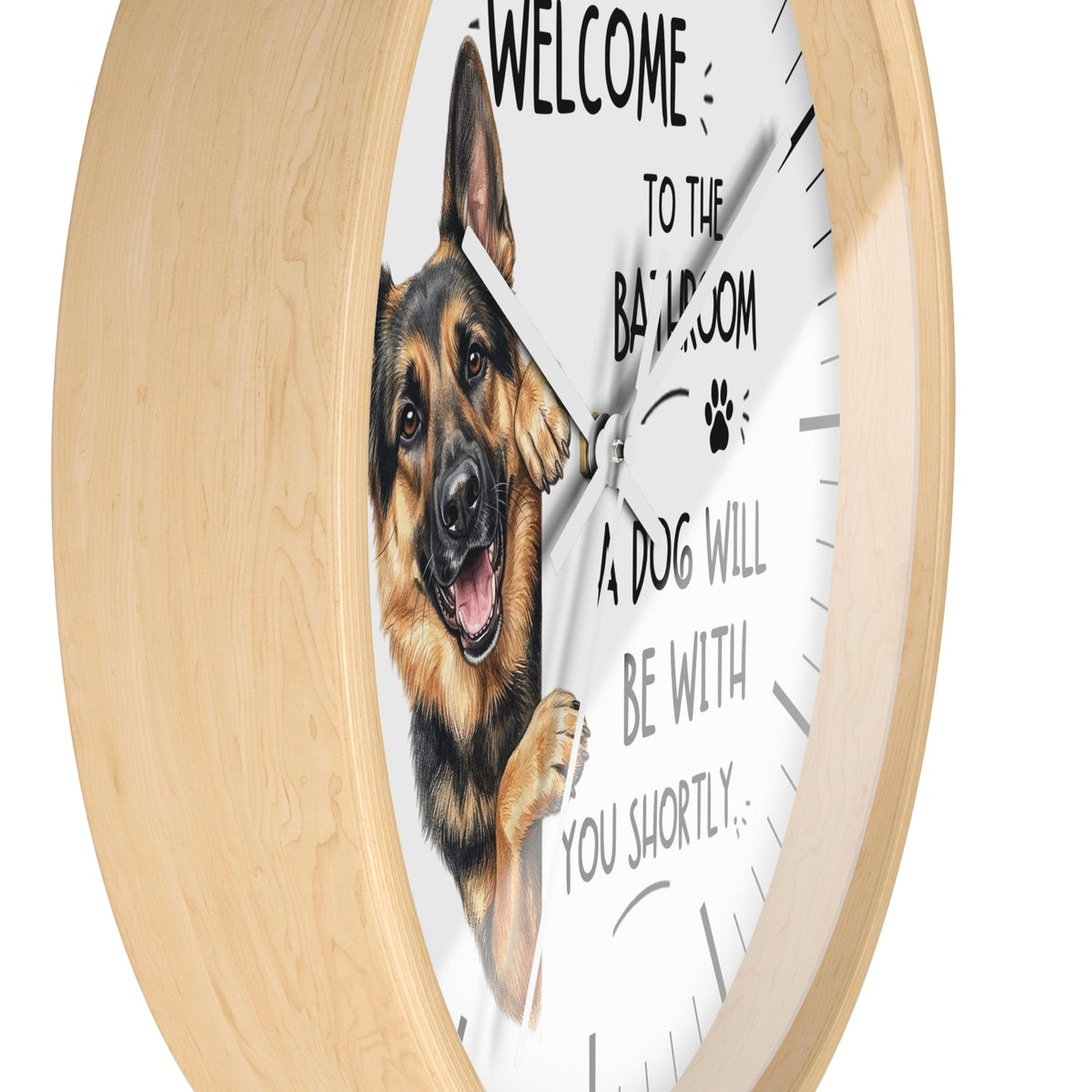 A round wall clock with a light natural wood frame and a white face featuring a German Shepherd illustration and the text 'WELCOME TO THE BATHROOM A DOG WILL BE WITH YOU SHORTLY'