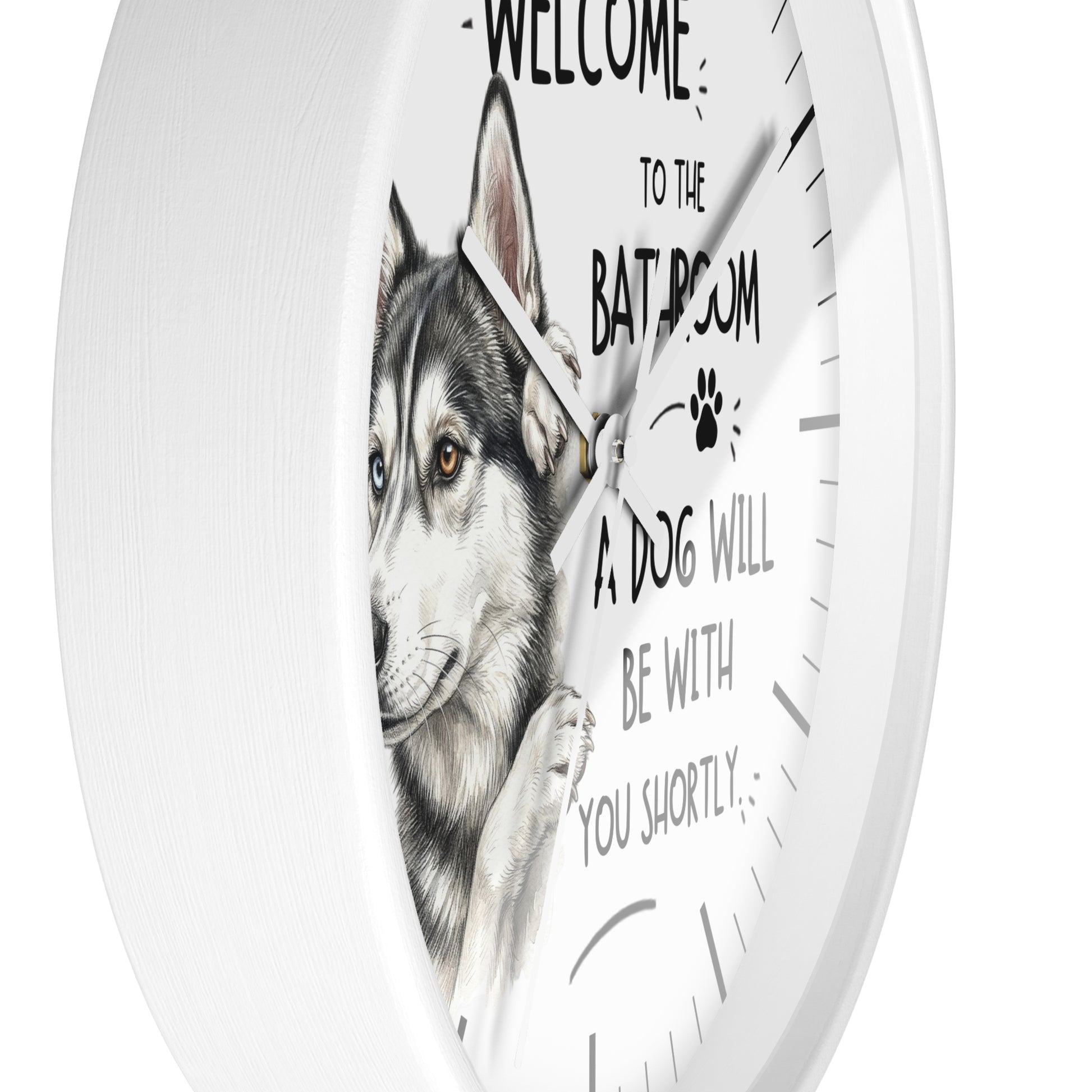 A round white wall clock with a printed illustration of a husky dog and the text 'WELCOME TO THE BATROOM A DOG WILL BE WITH YOU SHORTLY' on the front.