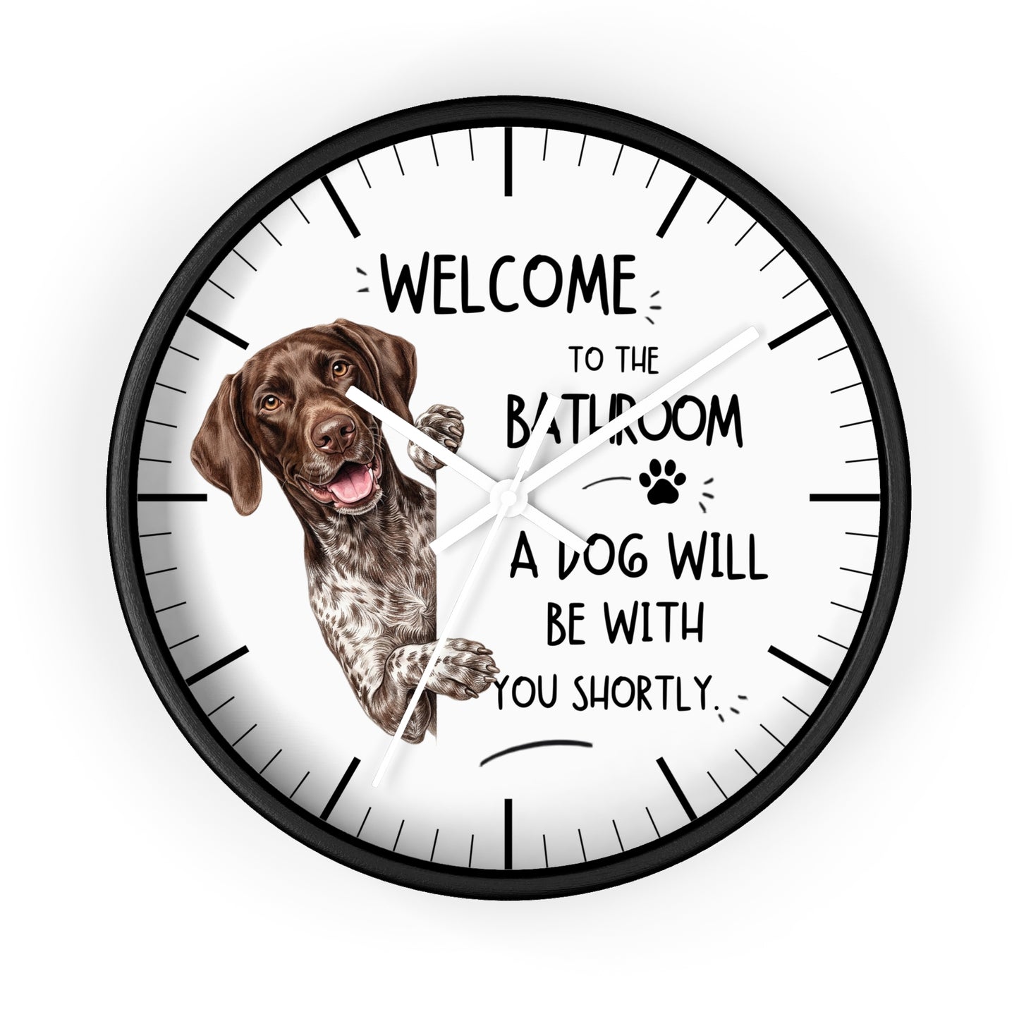 A round wall clock with a black frame and white face, featuring a German Shorthaired Pointer dog illustration and the humorous text 'WELCOME TO THE BATHROOM A DOG WILL BE WITH YOU SHORTLY.'.