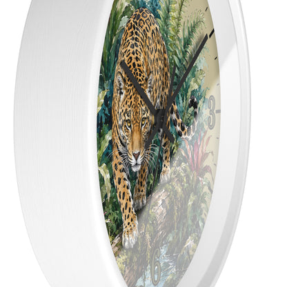 A round wall clock with a white frame and a printed tropical jungle scene featuring a large spotted big cat, likely a leopard or jaguar, walking forward. The clock face has black hands and partial black numerals, shown against a plain white background.