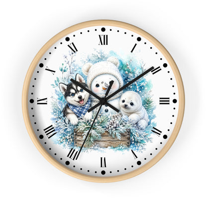 A round wall clock with a light wood frame and a white face, featuring a winter illustration of a snowman, a husky, and a polar bear surrounded by blue foliage and pine branches. The clock has black Roman numerals and hands on a clean white background.