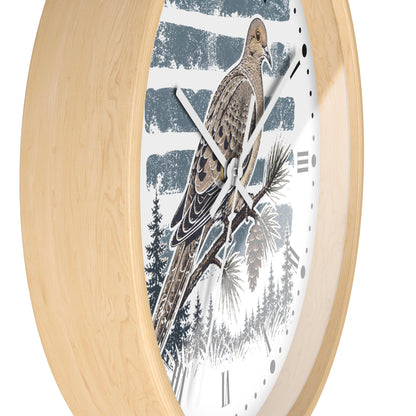 A close-up of a wall clock with a light natural wood frame and a white dial featuring a detailed illustration of a brown dove bird perched on a pine branch against a blue-gray striped background.