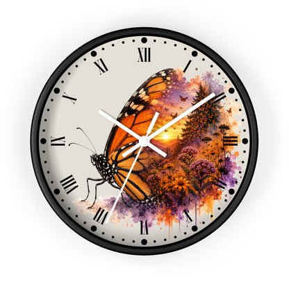 Round wall clock with a black frame and a printed butterfly artwork over a watercolor-style floral background. The clock face is light beige with black Roman numerals and white hands.