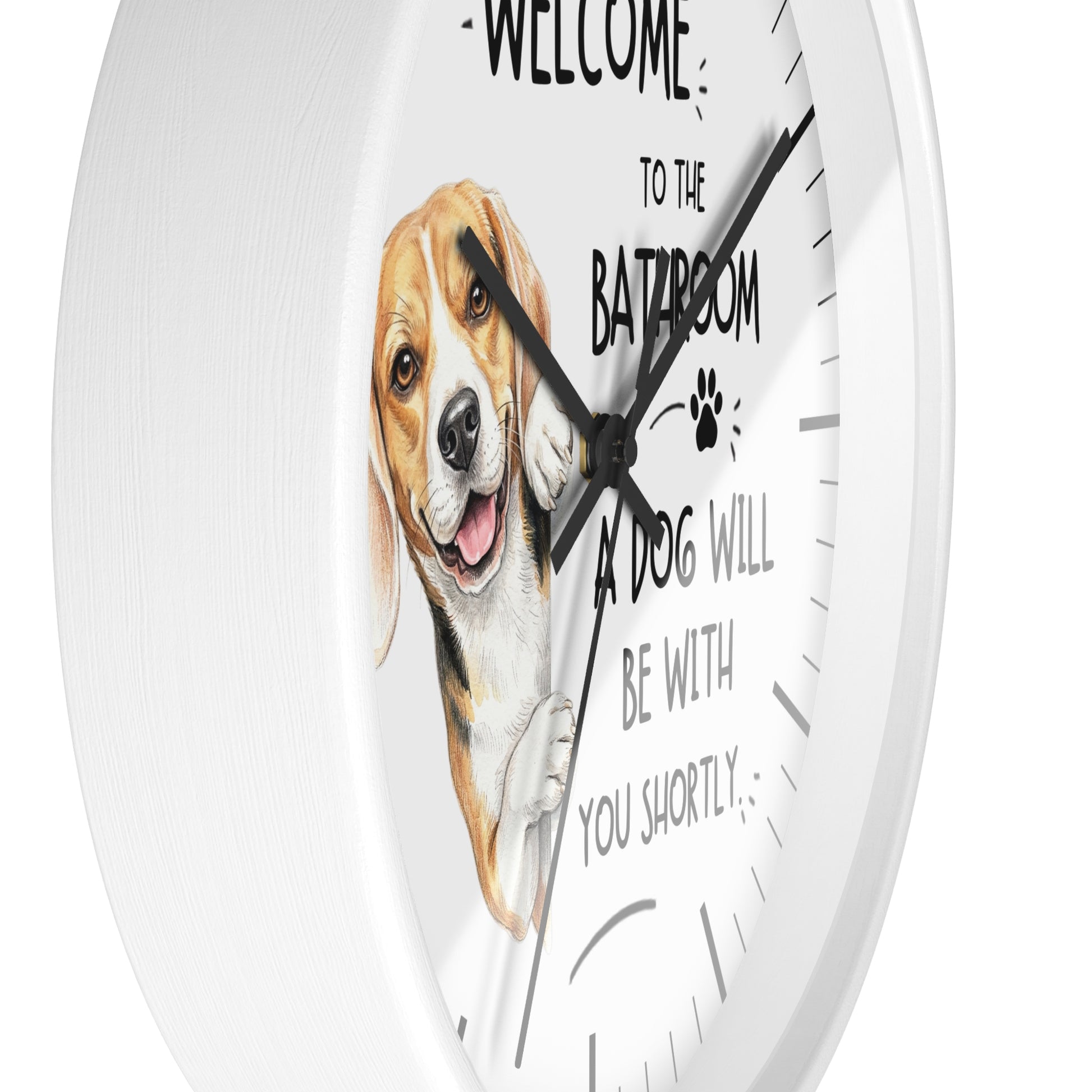 A round white wall clock with a humorous pet quote and a painted beagle illustration. The text reads 'WELCOME TO THE BATHROOM A DOG WILL BE WITH YOU SHORTLY' with a paw print, displayed against a clean white background.