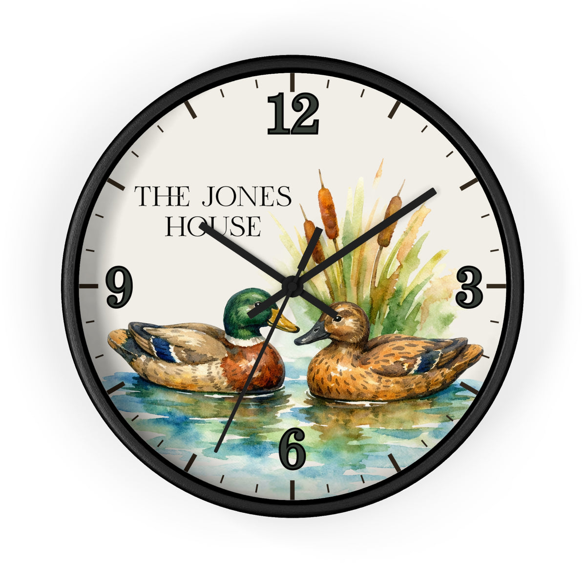 A round wall clock with a black frame and a custom illustrated dial showing two mallards on water with the text 'THE JONES HOUSE' at the 9 o'clock position. The clock is photographed against a clean white background.