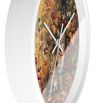 Round wall clock with a white frame and a printed autumn scene featuring a cat among leaves and red berries, shown against a plain white background.
