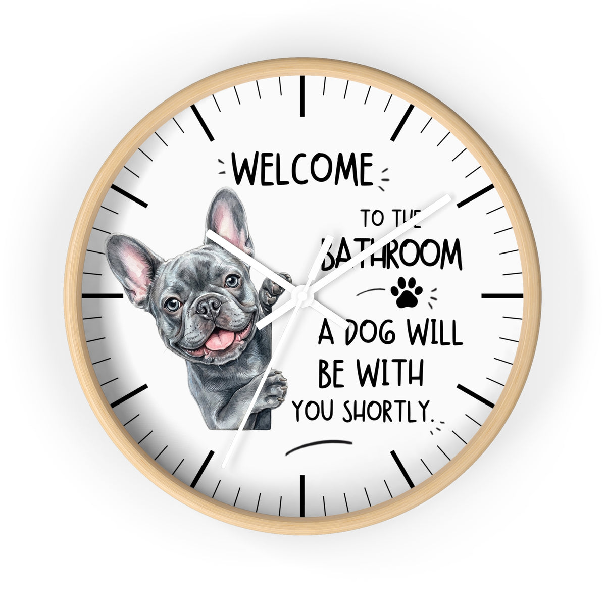 A round wall clock with a light wood frame and a white face, featuring a French bulldog illustration and the text 'WELCOME TO THE BATHROOM A DOG WILL BE WITH YOU SHORTLY.' on a plain white background.