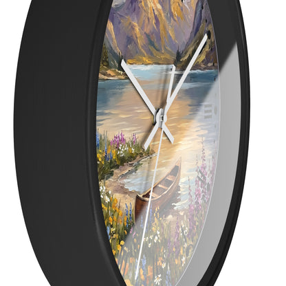 Round wall clock with a black frame and a scenic landscape print featuring a lake, mountains, flowers, and a canoe, shown against a white background.